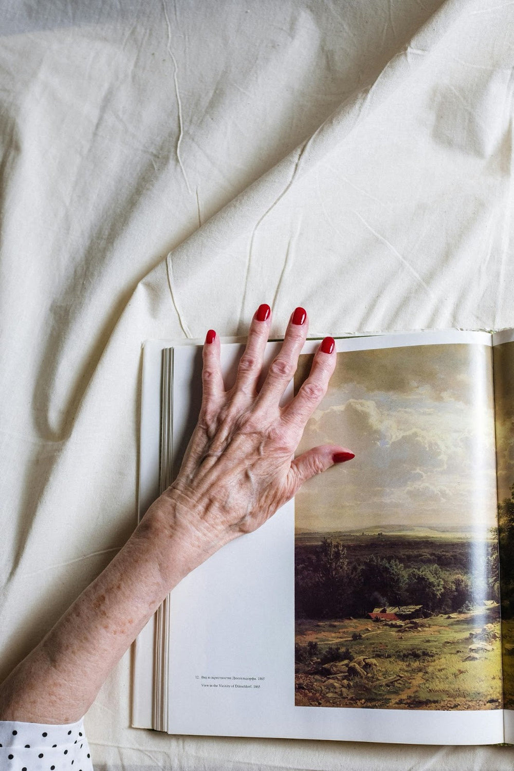Older Woman’s Fingernails on Book